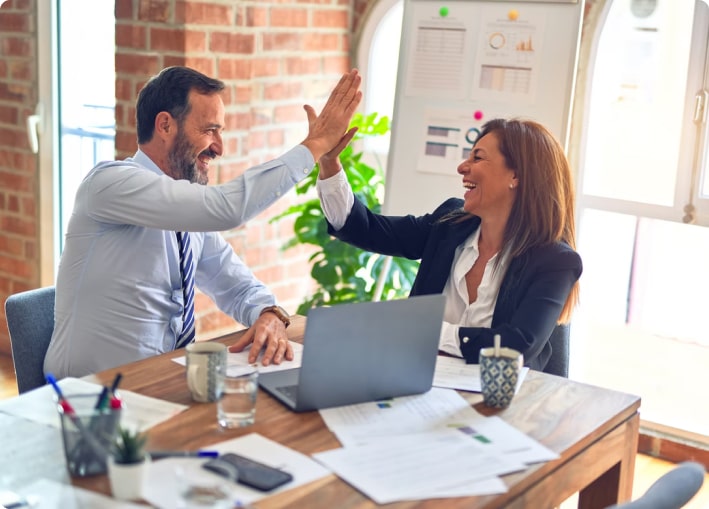woman and man high fiving in an office